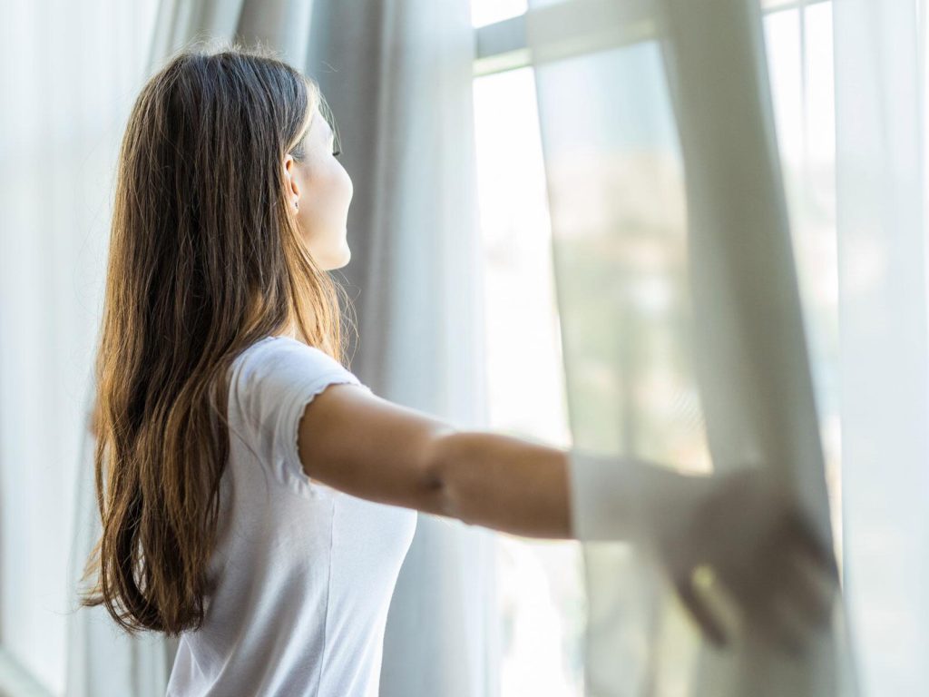 Moderner heller Innenraum bleibt im Sommer angenehm kühl durch Sonnenschutzfolie auf großen Fenstern